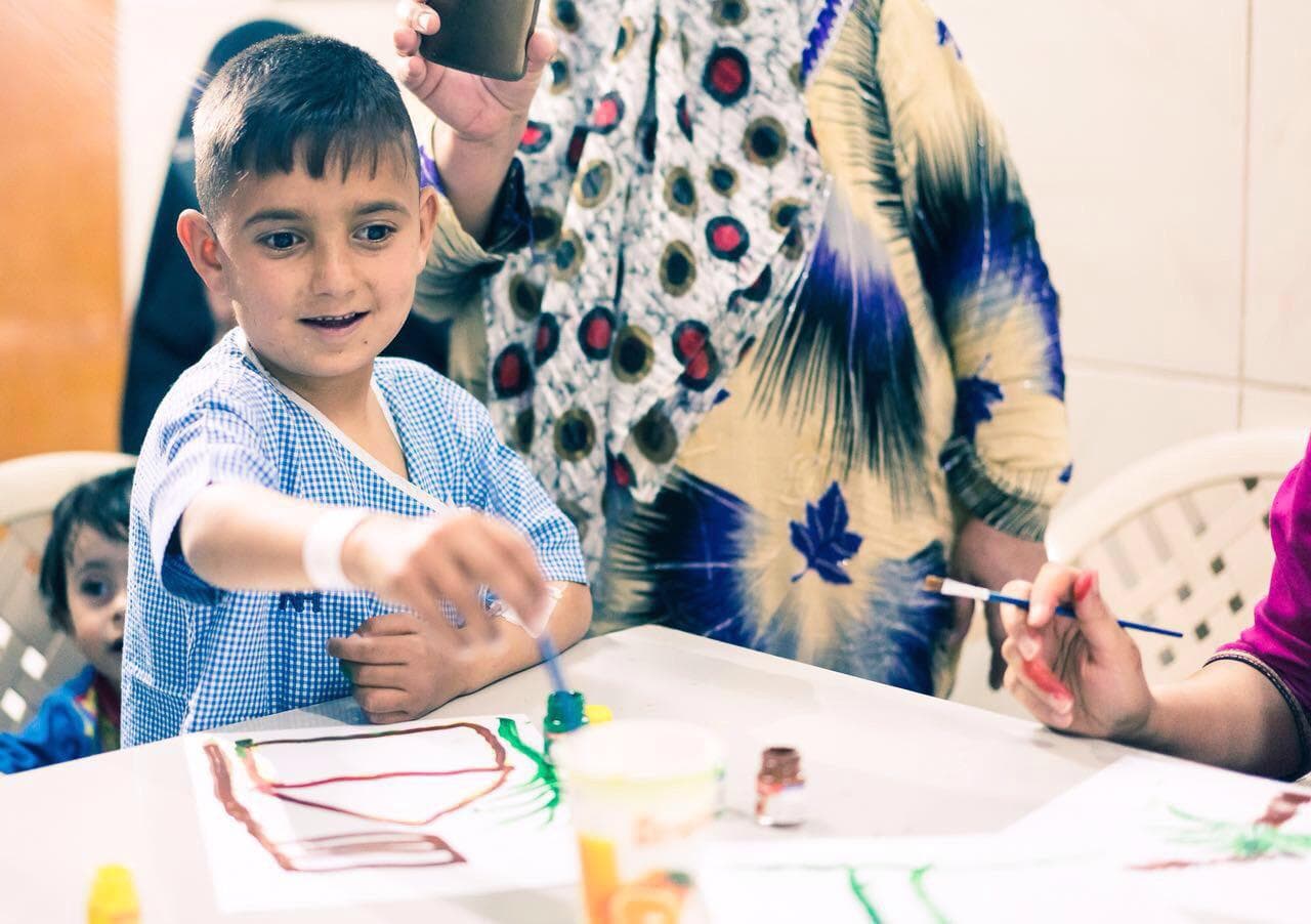 A boy painting during the treatment program in India